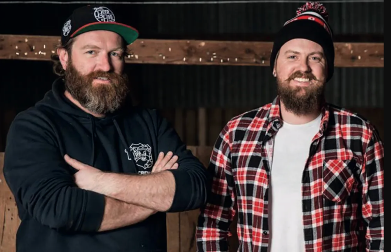 Gareth Lewis and Aaron Sandow of General Admission Entertainment posing together in a cap and beanie for a portrait photo.